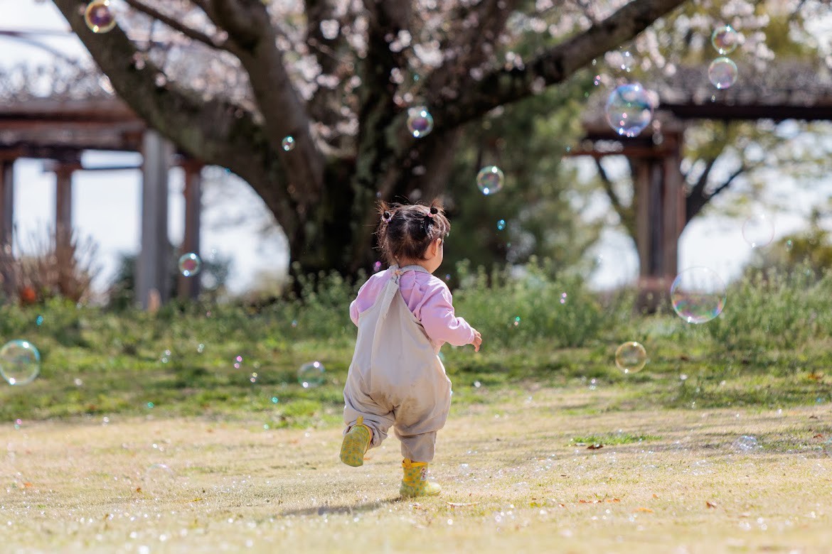 しゃぼん玉を追いかける小さな子ども