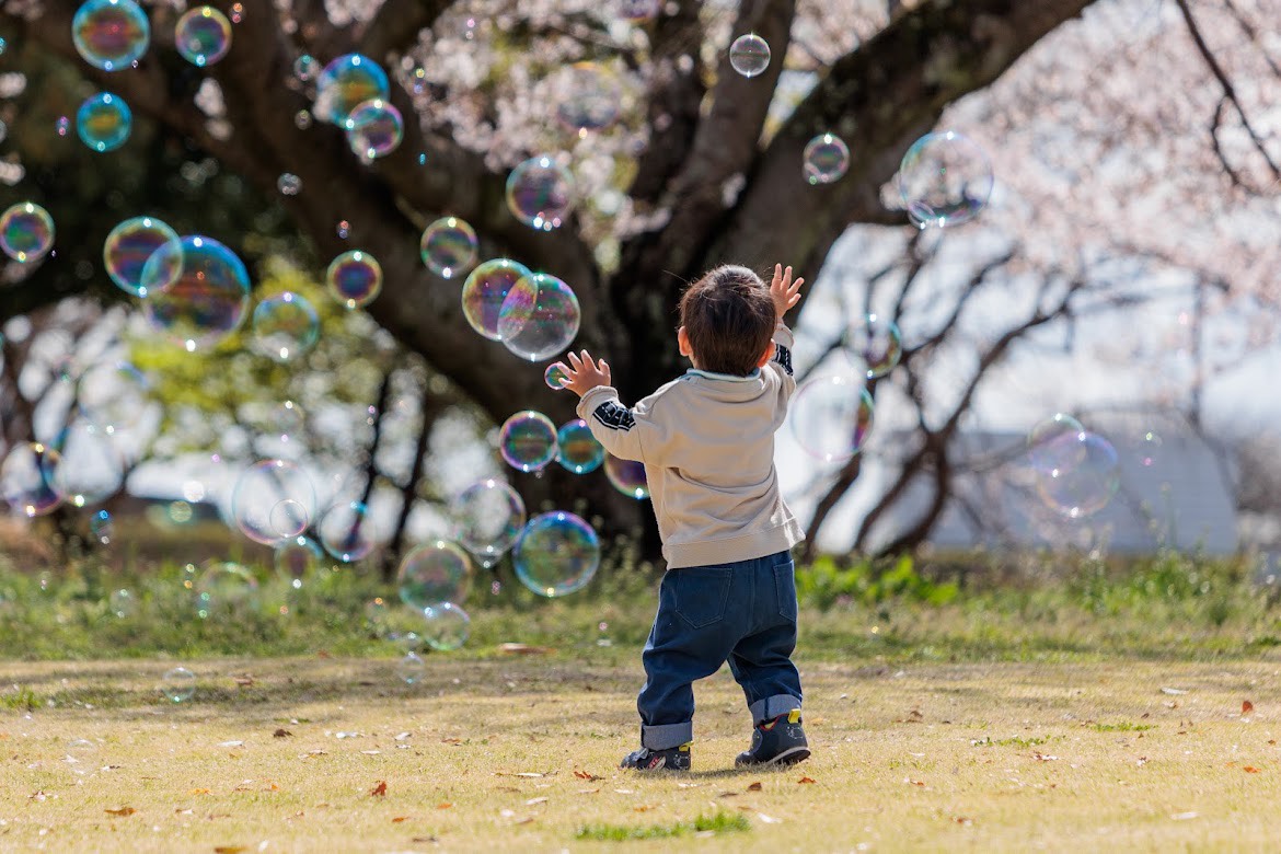 光るしゃぼん玉を眺める子ども