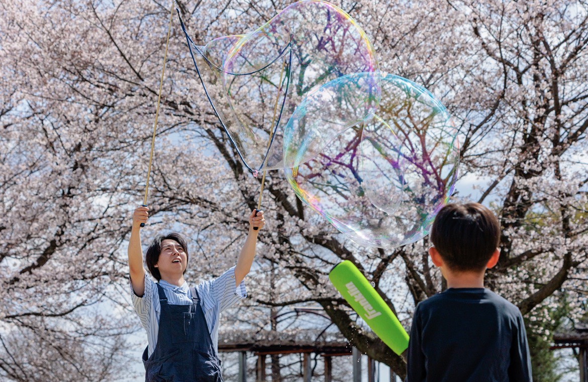 桜の下で巨大しゃぼん玉を作る様子